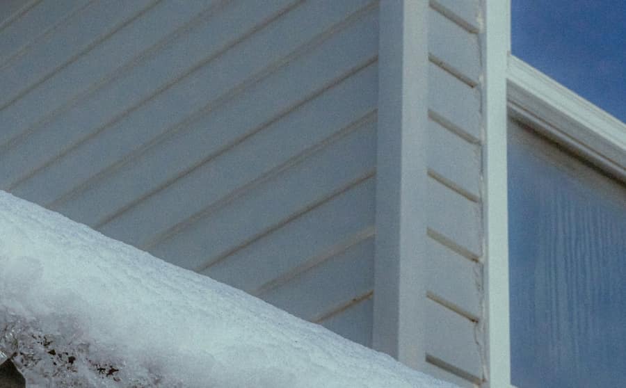 Snow and ice along the eave of a house roof